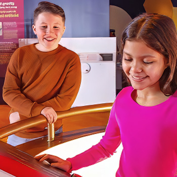 CT Science Center showing 2 elemetary students engaged with interactive space display 
